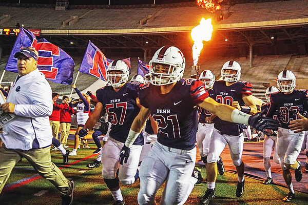 Football players run onto field before game