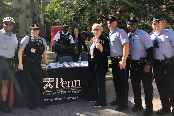 Uniformed police officers pose in front of a table on Locust Walk