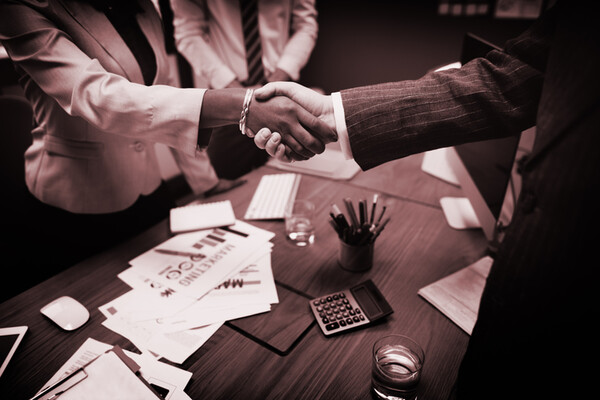closeup of a handshake between a man and woman over a table