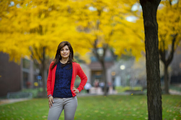 Florian stands in front of tree with autumn leaves