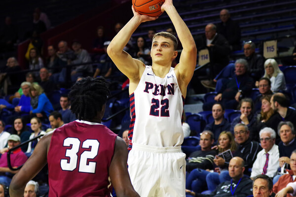 Kuba Mijakowski of the men's basketball team shoots a jump shot.