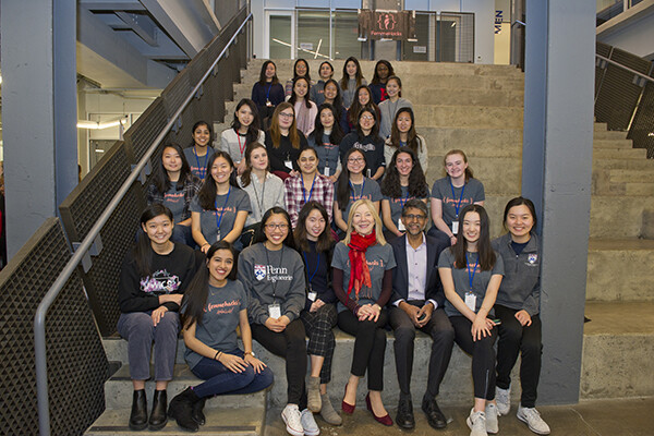 Amy Gutmann sitting on the steps at the Pennovation center with attendees of FemmeHacks