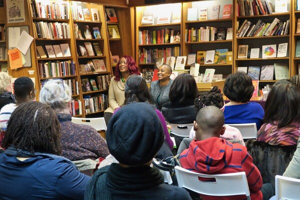 Feminista Jones and Tanji Gilliam seated in front of a small crowd at the Penn Book Center