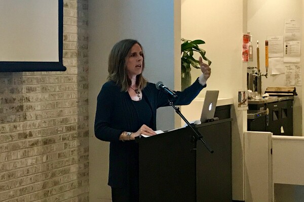 Meta Mazaj speaking at podium.
