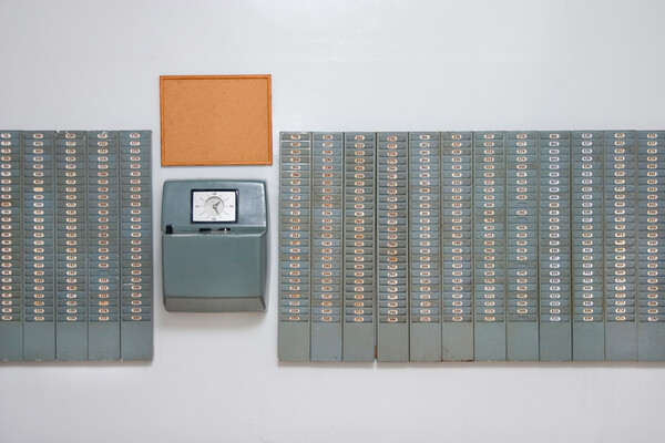wall with time cards and a timeclock