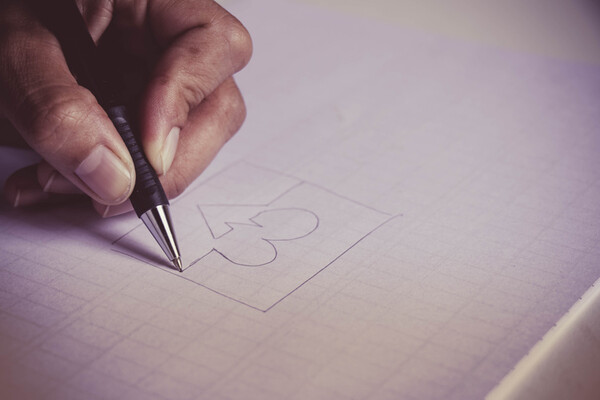 hand holding a pen drawing a heart icon