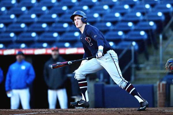 Sophomore infielder Eduardo Malinowski watches the ball from the batters box after a hit.
