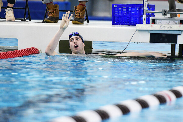 Mark Andrew holds up four fingers after winning four straight 200 IM at Ivy Championships.