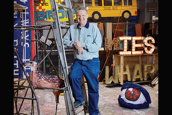 Peter Whinnery posing on a ladder in his workshop