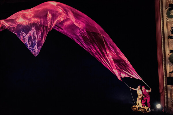 Tapestry held by two people blows in the air