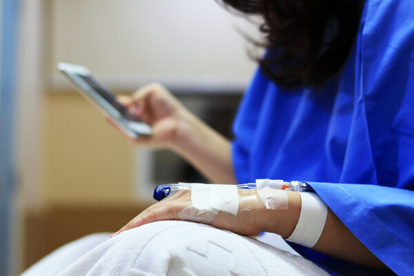 person with IV holding a cellphone