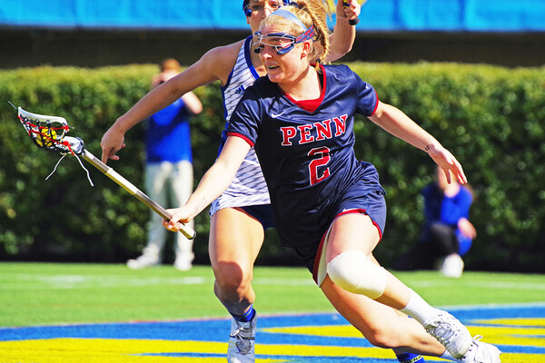 Midfielder Erin Barry makes a move with ball in stick during a game.