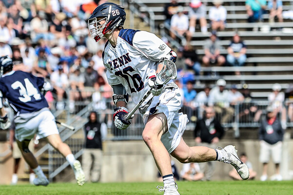 Freshman midfielder Sam Handley of the lacrosse field runs up the field with his stick in his hands.