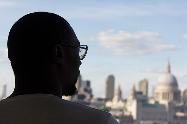 Back of a person's head overlooking a city horizon.