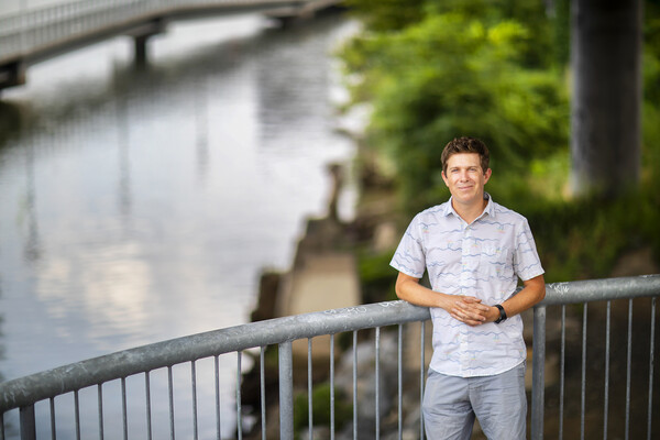 Doug Jerolmack leans against railing with river in background