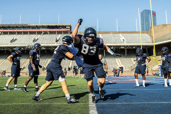 Football players take part in blocking drills in the endzone at Franklin Field during training camp.