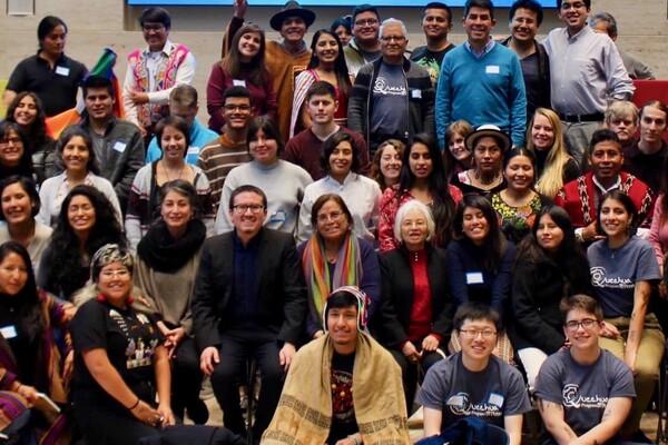 About 50 people gathered together some in indigenous clothing. 
