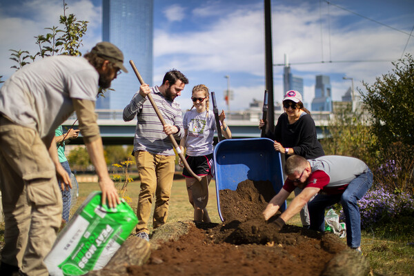 emptying dirt from wheelbarrow with city in the background