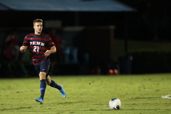 Jack Rosener, a midfielder on the men's soccer team, prepare to kick the ball during a game.