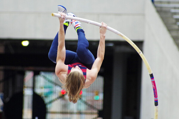 Senior Sean Clarke leaps into the air while performing the pole vault during a meet.