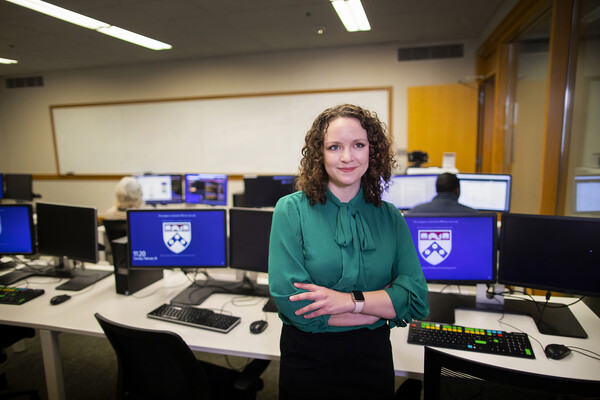 Person standing in front of row of desktop computers