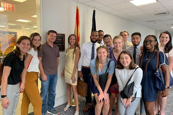 A group of students standing in front of two flag.