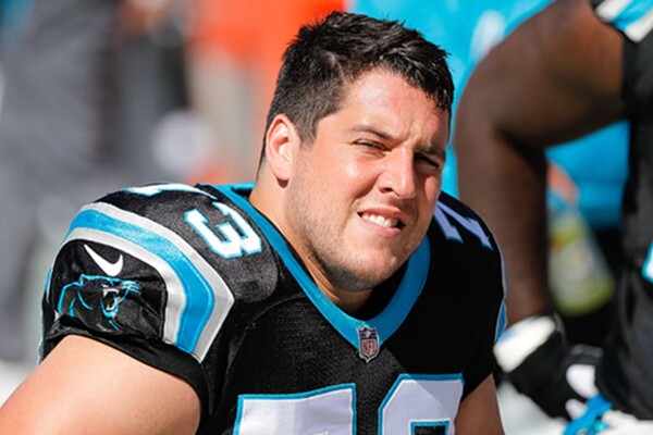 The Carolina Panther's Greg Van Roten sits on the bench during a game.