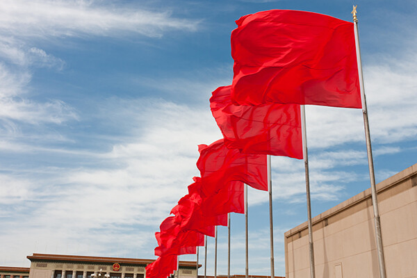 Row of Chinese flags outside a Chinese government building in daylight