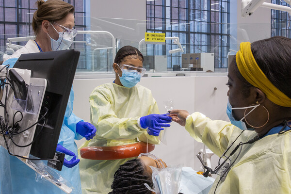 dental medicine with technicians handing off plastic bag