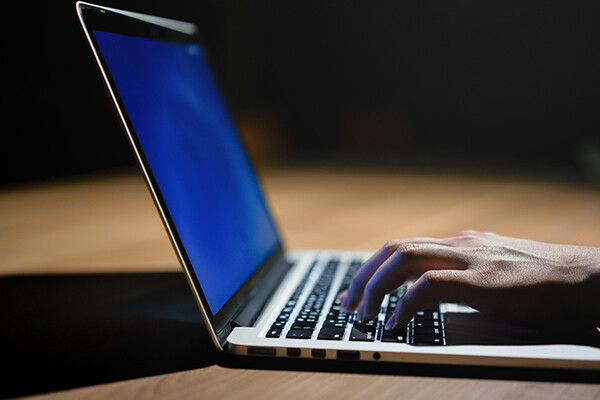 hands typing on a laptop keyboard