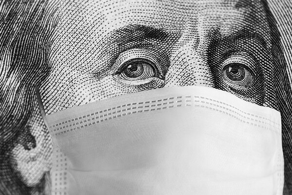 Closeup of Ben Franklin’s face on the bank note with a protective mask around his mouth and nose