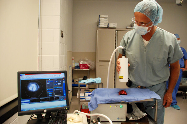 Surgeon uses an imaging machine to assess a tumor