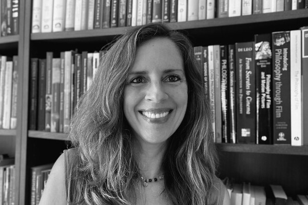 Professor in front of a bookshelf filled with books