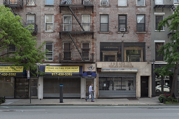 City sidewalk with storefronts empty, for rent signs on awning.