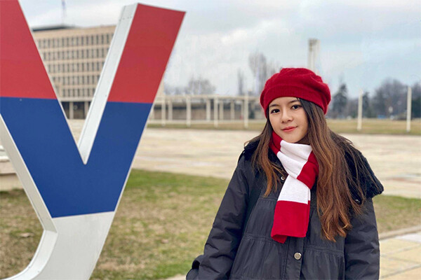Linya (Leah) Liu standing outside wearing a coat, hat and scarf.