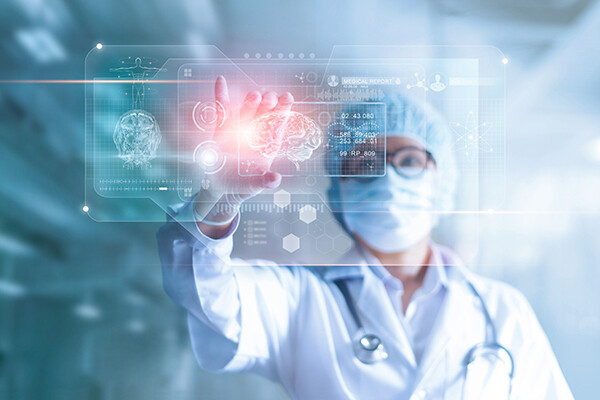 Doctor in protective gear looks at a brain scan projected on transparent screen