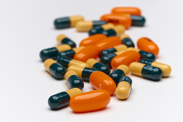 multicolored HIV medication capsules spilled out on a surface.