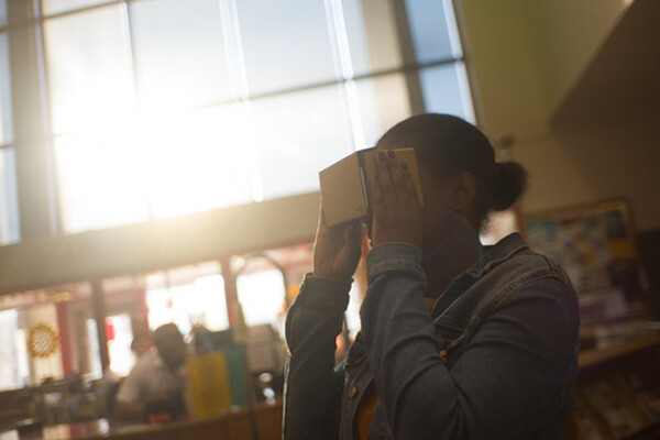 person holding a virtual reality headset to their eyes.