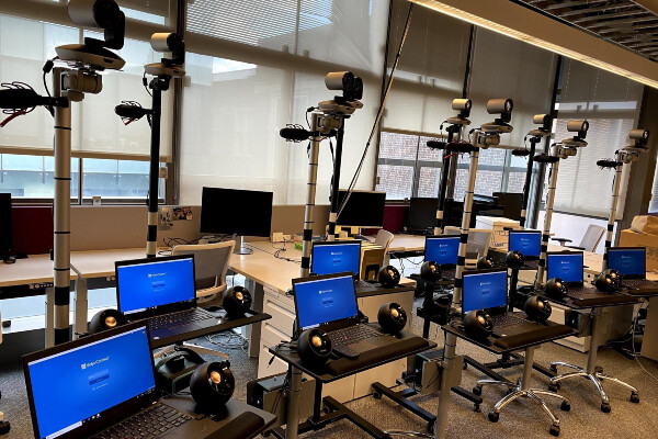 laptops on rolling carts next to speakers and with a camera mounted on the top
