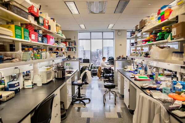 a person at the far end of a lab working on a computer
