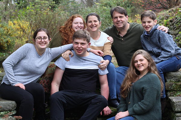 Amy Lutz seated with her husband and children in nature.