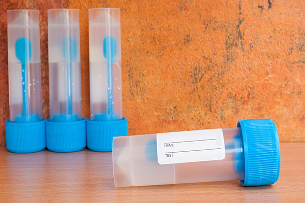Four empty vials for human stool samples.