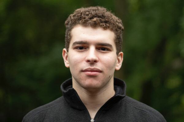 student in front of green background