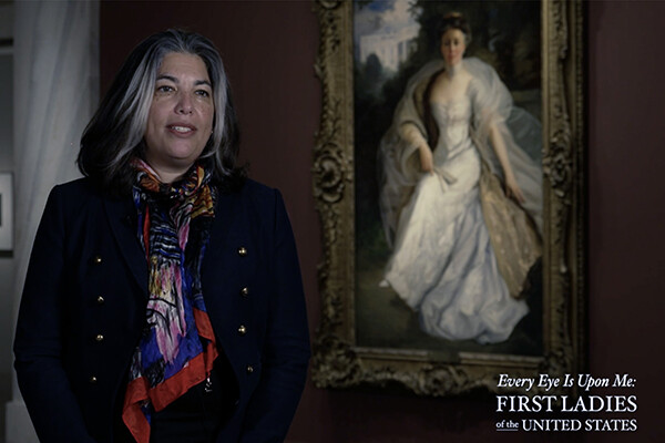professor standing in front of a painting in a museum gallery