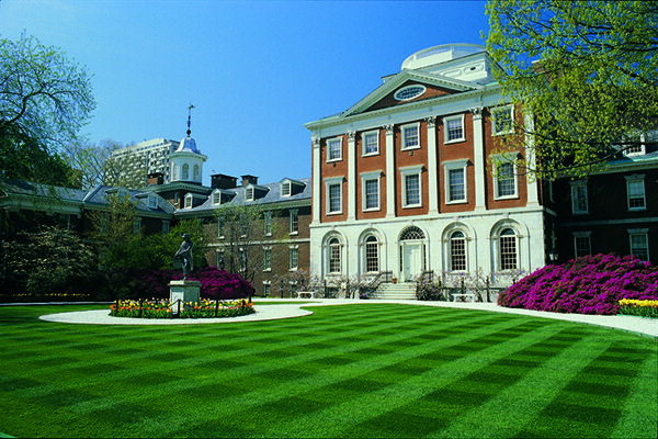 View of the front Pennsylvania Hospital building with green lawn and gardens.
