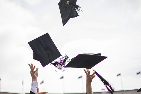 Graduation caps thrown in air