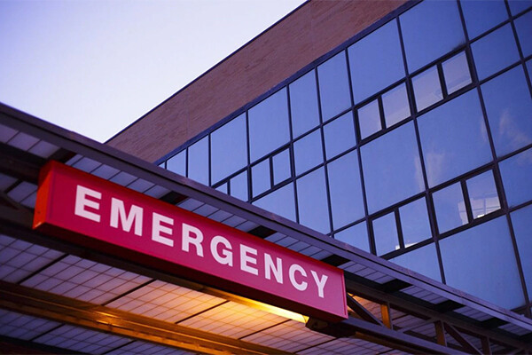 Neon EMERGENCY sign on front of hospital.