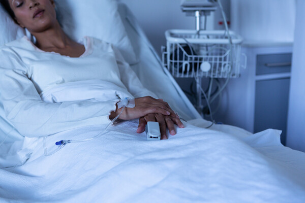 Relaxed patient asleep in a hospital bed.