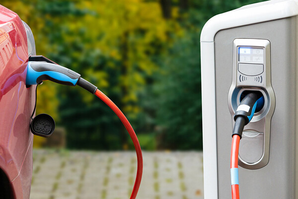 An electric vehicle plugged into a recharge station.