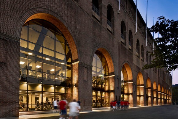 An exterior shot of the Fox Fitness Center at Weiss Pavilion, with groups of people running outside.